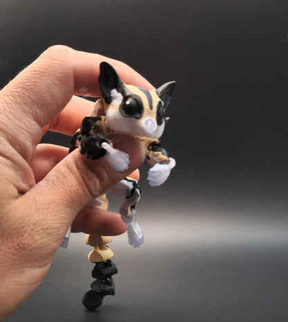 Hand holding a detailed 3D printed sugar glider figurine against a dark background