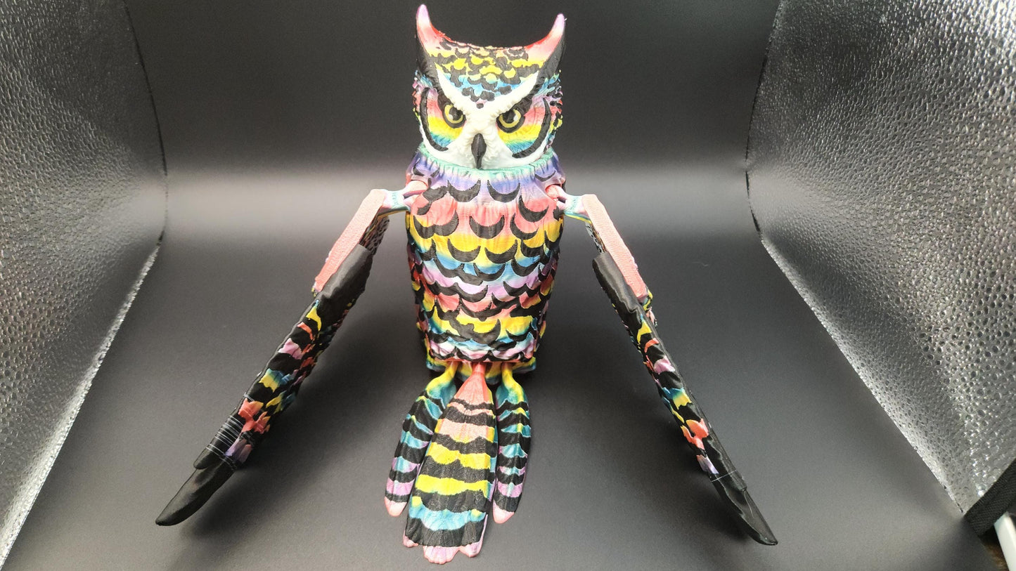 Poseable articulated rainbow great horned owl figure with colorful feathers and extended wings