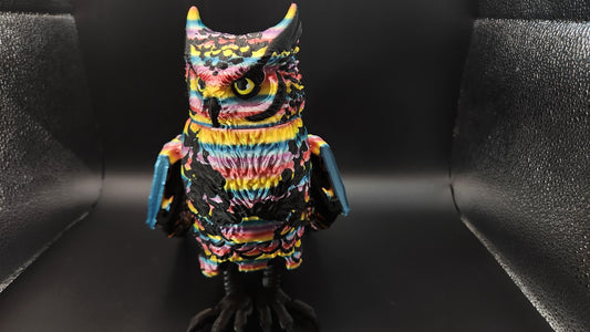 Colorful poseable articulated rainbow great horned owl figurine with detailed feathers on black background