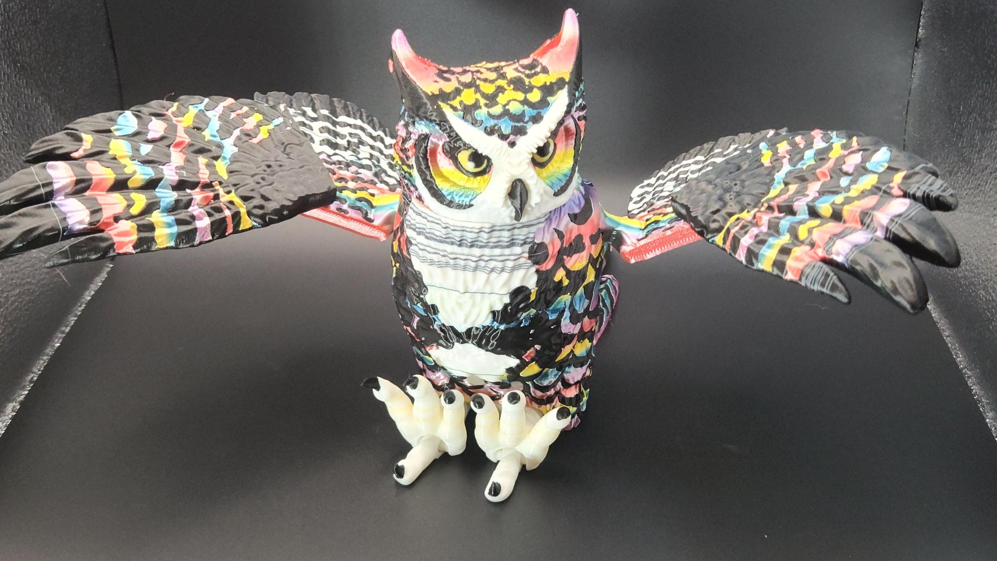 Poseable articulated rainbow great horned owl with colorful detailed feathers and spread wings