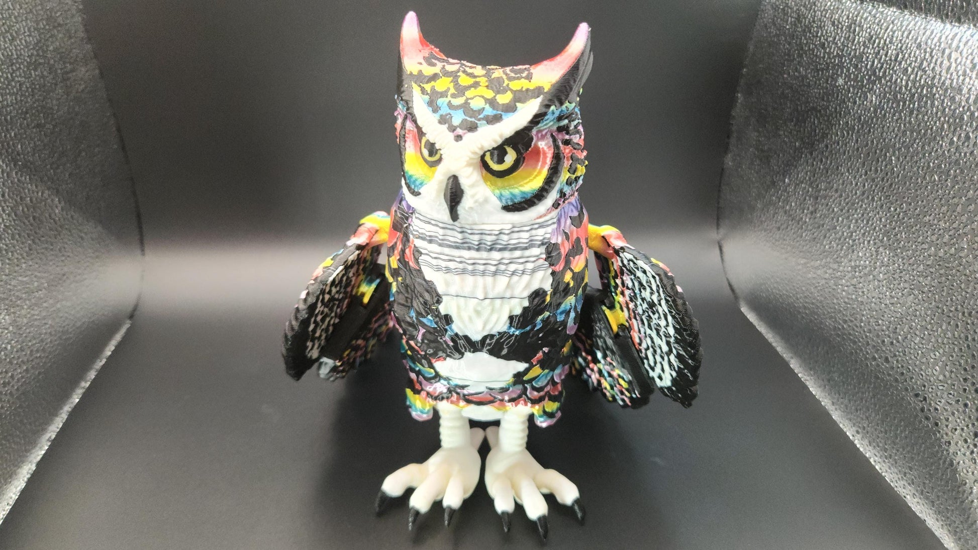 Poseable articulated rainbow great horned owl figurine with colorful detailed feathers and spread wings