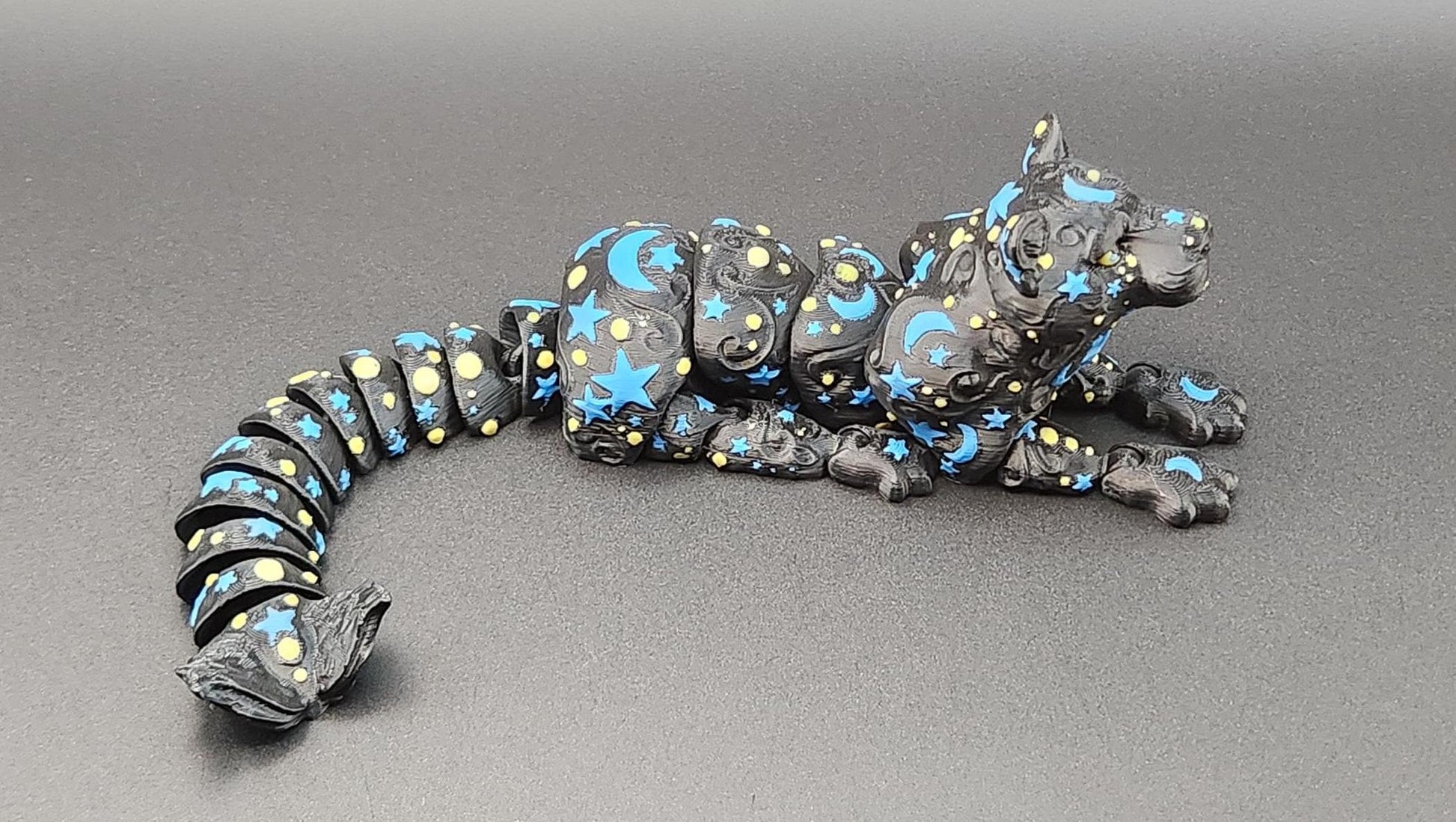 Star and moon fidget panther toy with black segmented body decorated with blue stars and crescent moons