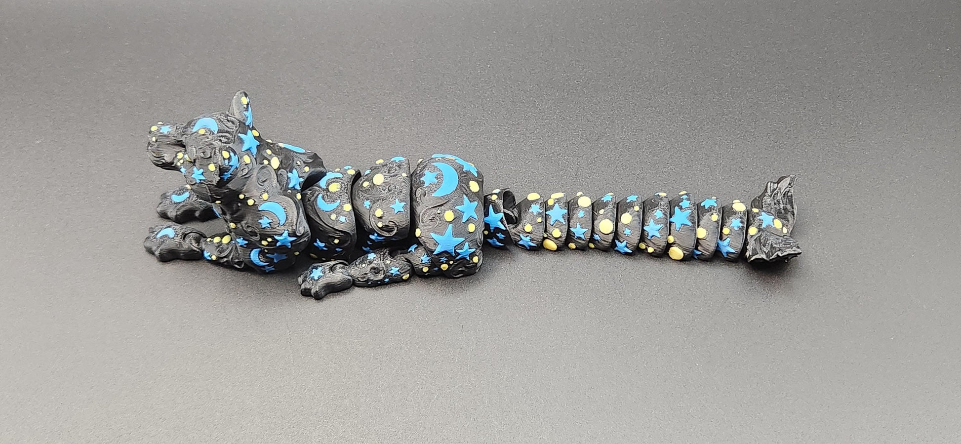Black star and moon fidget panther toy with blue and yellow celestial patterns