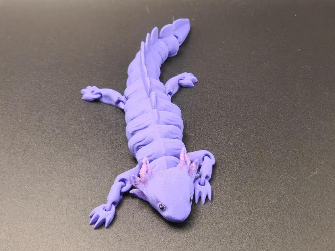 Purple wiggly axolotl figurine with detailed limbs and tail on black background